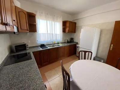 a kitchen with a table and a white refrigerator at Casa a Torre in Santa Cruz