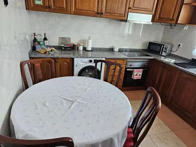 a kitchen with a table and a stove and a dishwasher at Casa a Torre in Santa Cruz