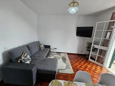 a living room with a gray couch and a tv at Casa a Torre in Santa Cruz