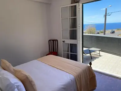 a bedroom with a bed and a view of the ocean at Casa a Torre in Santa Cruz