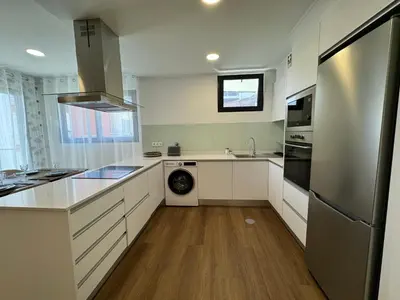 a kitchen with white cabinets and a stainless steel refrigerator at Stay In Virtudes I in Funchal