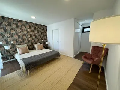 a bedroom with a bed and a chair at Stay In Virtudes I in Funchal