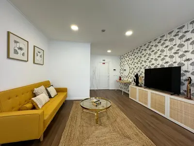 a living room with a yellow couch and a tv at Stay In Virtudes I in Funchal
