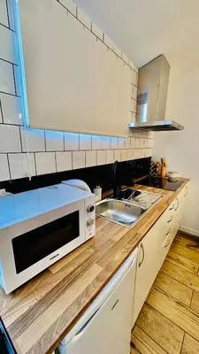a kitchen with a sink and a microwave on a counter at Cantinho das Pedras in Funchal