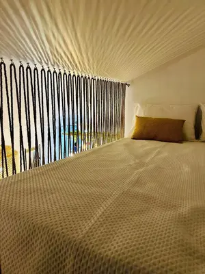 a bedroom with a large bed with a large window at Cantinho das Pedras in Funchal
