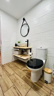 a bathroom with a toilet with a sink and a mirror at Cantinho das Pedras in Funchal
