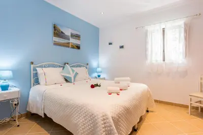 a blue bedroom with a bed with flowers on it at Beautiful house in Costa Vicentina in Chabouco