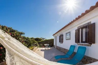 a hammock on a patio with a house at Beautiful house in Costa Vicentina in Chabouco