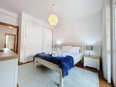 a bedroom with a bed and a chandelier at Moradia Uriel in Santa Cruz