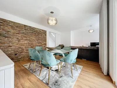 a dining room with a brick wall and a table and chairs at Moradia Uriel in Santa Cruz