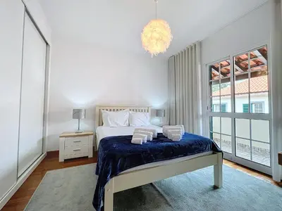 a bedroom with a bed and a chandelier at Moradia Uriel in Santa Cruz