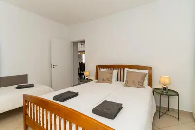 a bedroom with two beds with white sheets and pillows at Casa das Malvas in Porto Santo