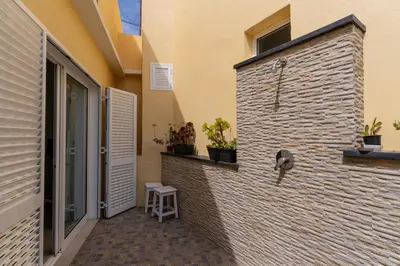 a brick wall with a stool next to a door at Casa das Malvas in Porto Santo