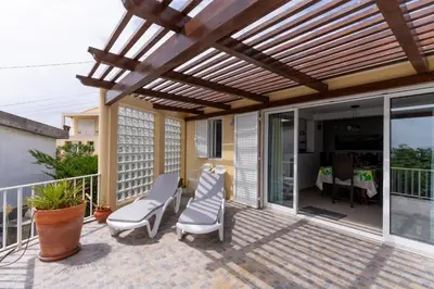 a patio with chairs and a wooden pergola at Casa das Malvas in Porto Santo