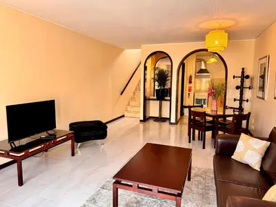 a living room with a couch and a table at Falesia Gardens in Caniço