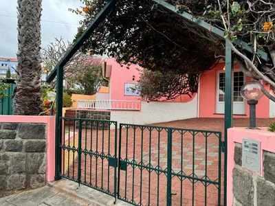 a gate in front of a pink house at Falesia Gardens in Caniço
