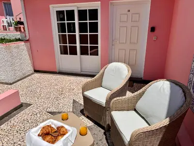 two chairs and a table with a bowl of food on a patio at Falesia Gardens in Caniço