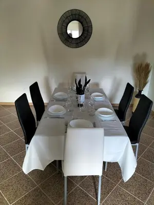 a dining room table with black chairs and a white table cloth at CASA Bela Vista in Machico