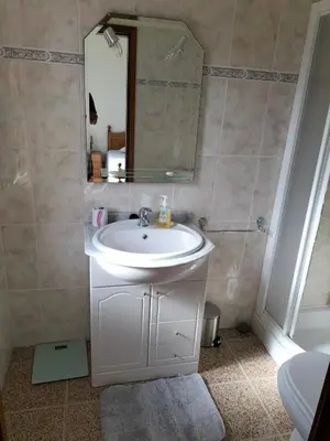 a bathroom with a white sink and a mirror at CASA Bela Vista in Machico