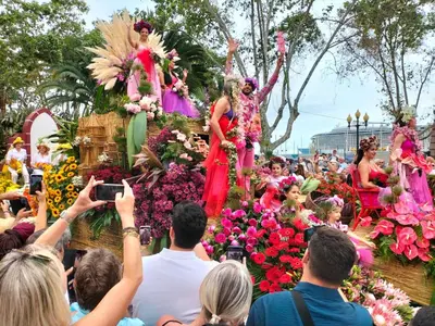 a crowd of people taking pictures of performers in flowers at CASA Bela Vista in Machico