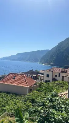 a group of houses on a hill next to the water at SOLMAR - Alojamento in Porto Moniz