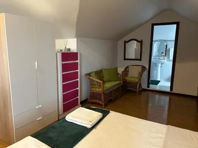 a living room with a chair and a mirror at SOLMAR - Alojamento in Porto Moniz