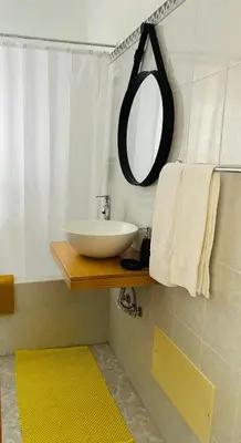 a bathroom with a sink and a mirror on a shelf at SOLMAR - Alojamento in Porto Moniz