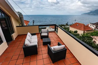 a balcony with couches and a view of the ocean at SOLMAR - Alojamento in Porto Moniz