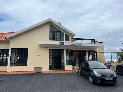 a car parked in a parking lot in front of a building at SOLMAR - Alojamento in Porto Moniz