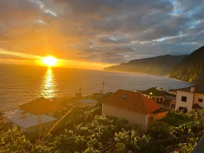 a sunset over a town and the ocean with houses at SOLMAR - Alojamento in Porto Moniz