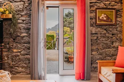 a room with a door open to a stone wall at Casa do Faial in Santana