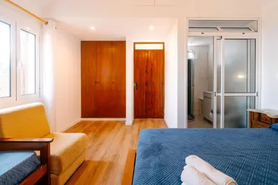a bedroom with a bed and a couch and a window at Casa do Faial in Santana