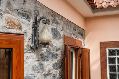 a stone wall with a lamp on a wall at Casa do Faial in Santana