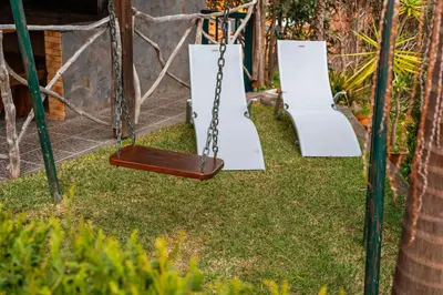 a swing set in a yard with grass at Casa do Faial in Santana