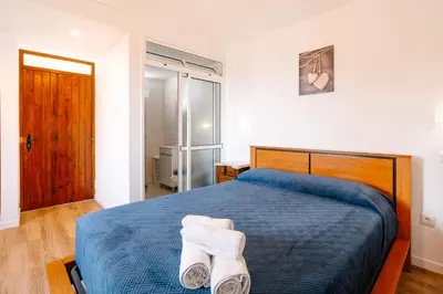 a bedroom with a bed with towels on it at Casa do Faial in Santana