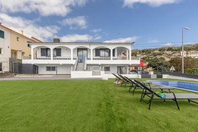 a large house with a swimming pool and a yard at Maylily Seascape Villa in Santa Cruz