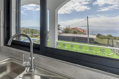 a kitchen sink with a view of the ocean from a window at Maylily Seascape Villa in Santa Cruz