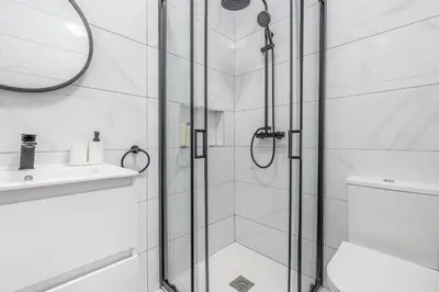 a bathroom with a shower with a glass door at Maylily Seascape Villa in Santa Cruz