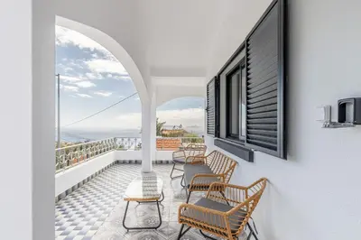 a balcony with chairs and a view of the ocean at Maylily Seascape Villa in Santa Cruz