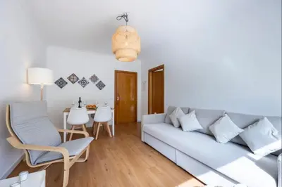 a living room with a couch and a tv at Casa Cláudia - Cond Atalaia in Lagos