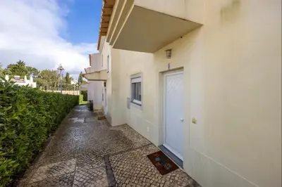 a living room with a television and a table with chairs at Casa Cláudia - Cond Atalaia in Lagos