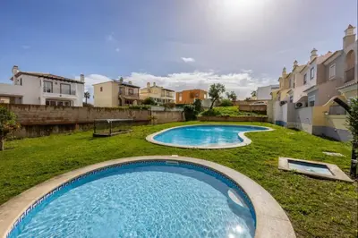 a large swimming pool in a yard with houses at Casa Cláudia - Cond Atalaia in Lagos