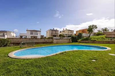 a swimming pool in a yard with houses in the background at Casa Cláudia - Cond Atalaia in Lagos