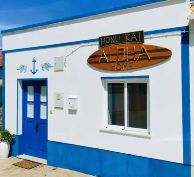 a surfboard on the side of a building at Honu Kai Aloha Home Sagres in Sagres