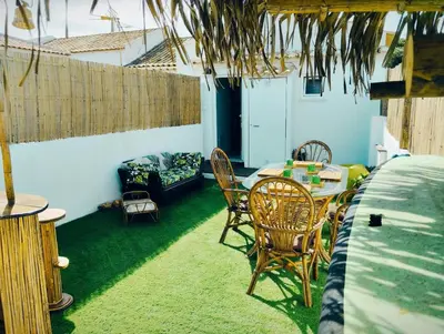 a patio with a table and chairs and a couch at Honu Kai Aloha Home Sagres in Sagres