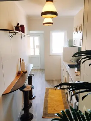 a kitchen with a counter and a table at Honu Kai Aloha Home Sagres in Sagres