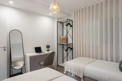 a bedroom with two beds and a desk with a laptop at Santa Cruz II by An Island Apart in Santa Cruz