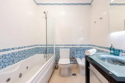 a bathroom with a tub and a toilet and a sink at Apartment República in Lagos