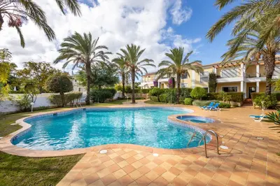 a swimming pool with palm trees and a house at Apartment República in Lagos