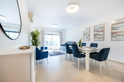a dining room with a white table and blue chairs at Apartment República in Lagos